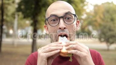 公园里的一个年轻秃头吃三明治。 不<strong>好吃</strong>的，不<strong>好吃</strong>的三明治